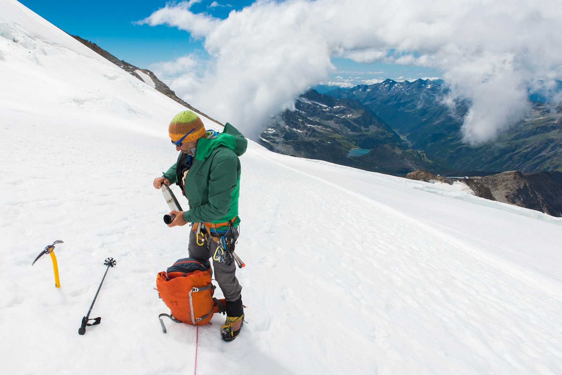 A climber alone on a glacier below high peaks